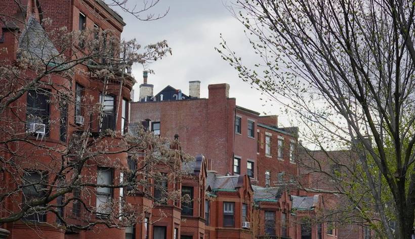 Historic red brick buildings on a tree-lined street